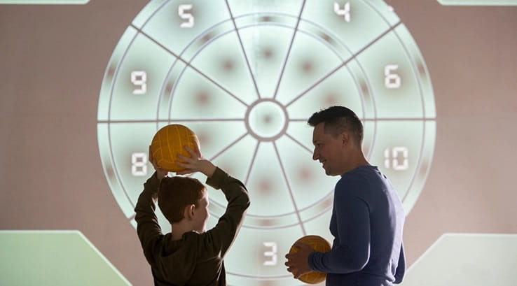 A father and son taking part in the interactive wall activity