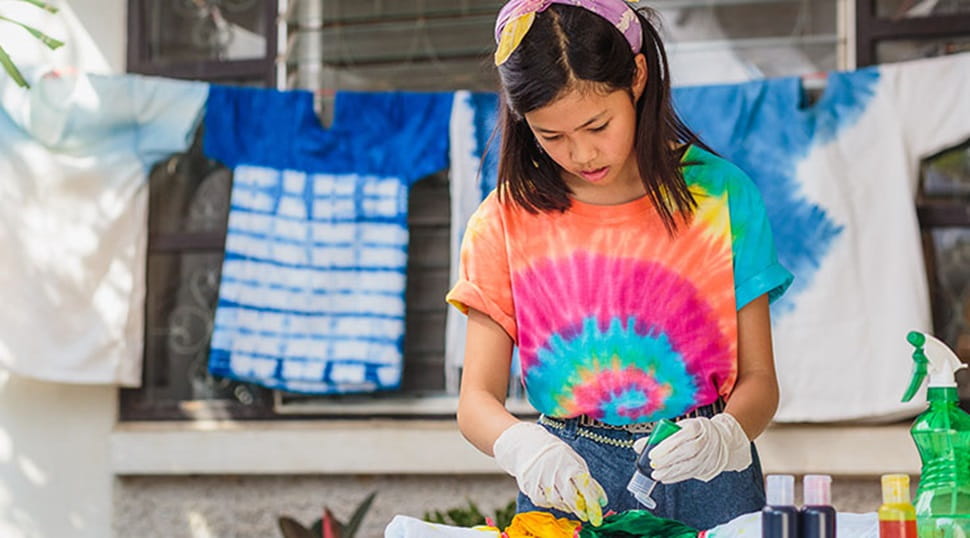 girl creating tie dye clothing