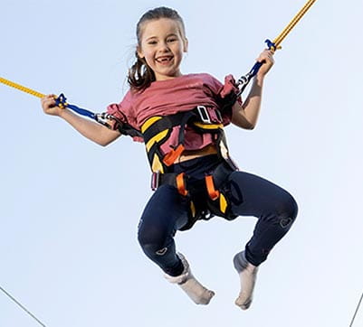 A child jumping up and down on the bungee trampolines