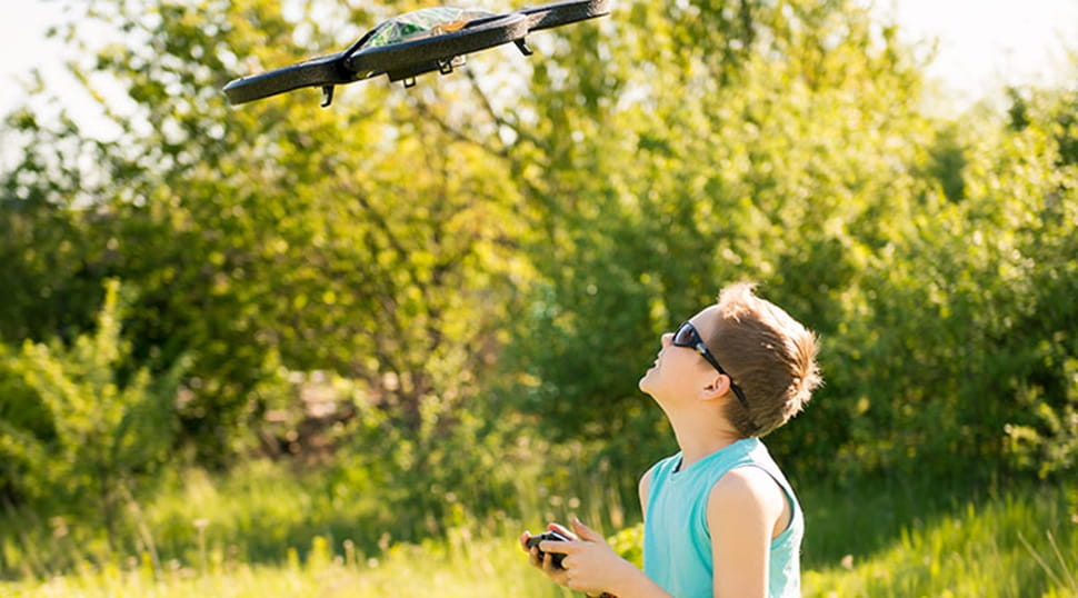 boy flying a mini drone in the sun