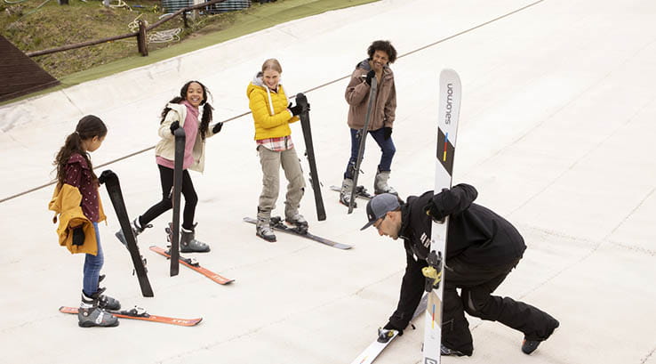 Children getting a ski lesson on a dry ski slope