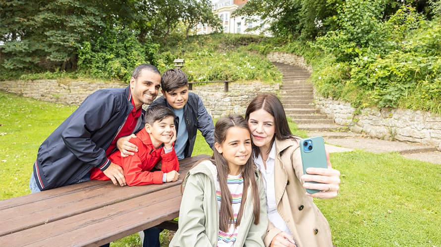 A family taking a selfie while sitting at a picnic bench