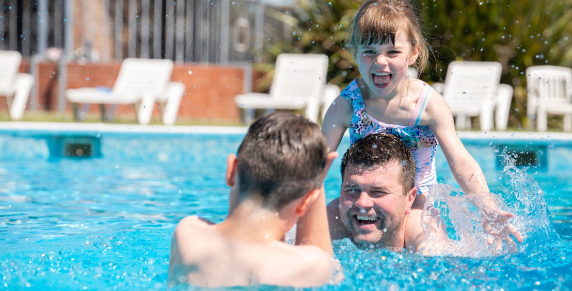 father with kids in swimming pool