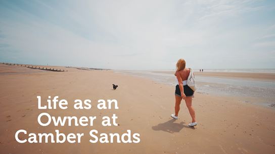Woman walking along a beach at Camber Sands