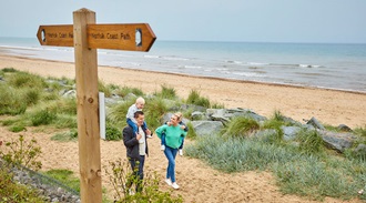 a family walking along a beach path