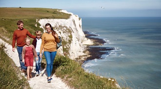 a family walking along a cliff top path