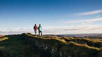 a couple walking along a ridge path
