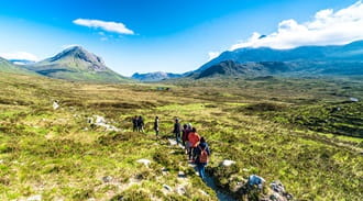 a group of walkers walking through the highlands
