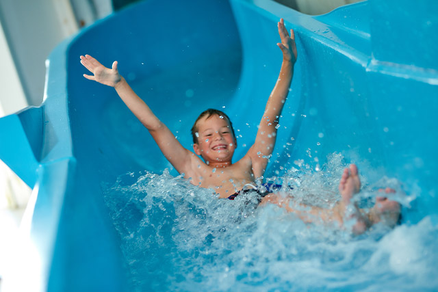 A boy sliding down the water slide at Carmarthen Bay Holiday Park