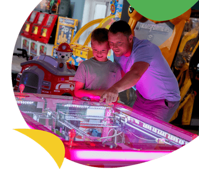 Father and son playing arcade games at Carmarthen Bay Holiday Park