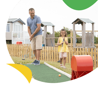 Father and daughter playing crazy golf at Crantock beach Holiday Park