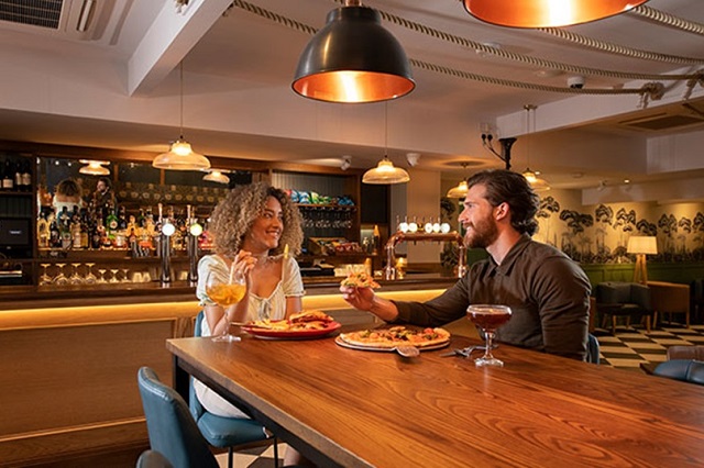 A couple enjoying food and drinks in the newly refurbished Willow restaurant at Fallbarrow