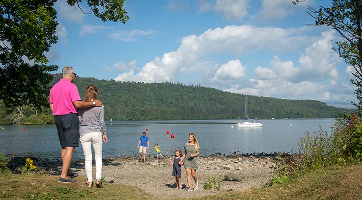 A family enjoying the views of Lake Windermere on a sunny day