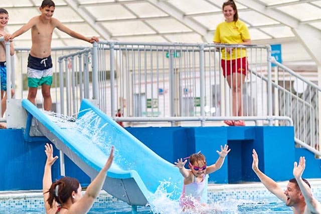 children having fun on the water slide at the indoor pool