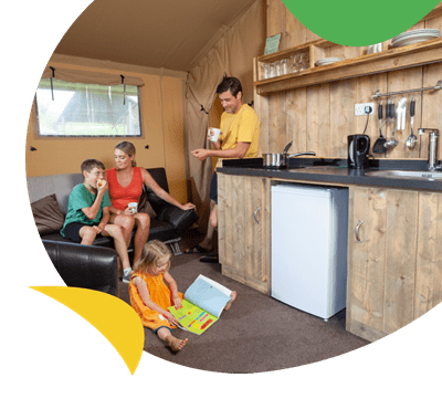 A family relaxing in a glamping tent at Holywell Bay Holiday Park