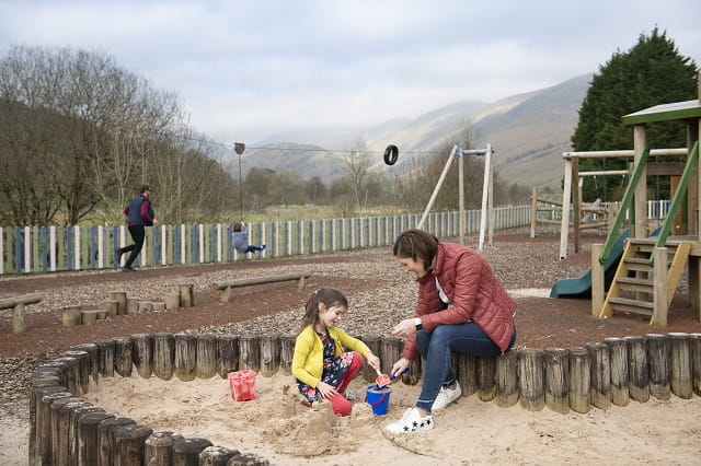 A family playing in the outdoor adventure playground at Limefitt Holiday Park