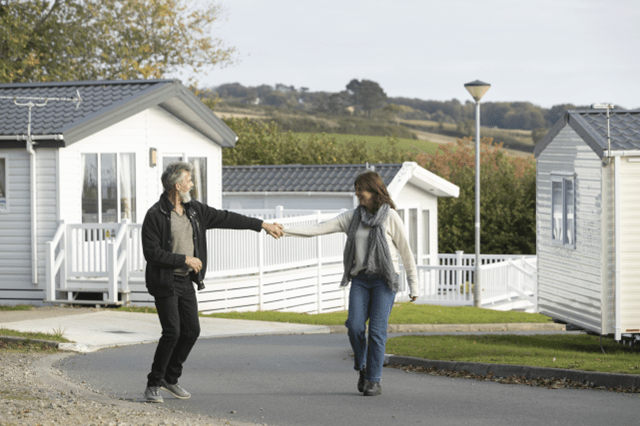 Couple outside park homes in Looe Bay