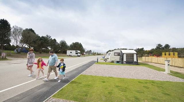 A family walking through the Touring and Camping site at Nairn Lochloy