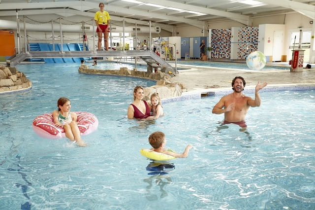 A family playing in the indoor swimming pool at Nodes Point Holiday Park