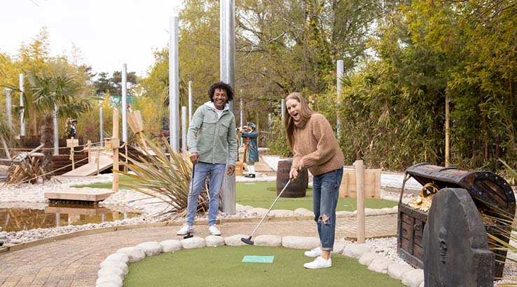A couple playing golf on the pirate crazy golf course at Sandford