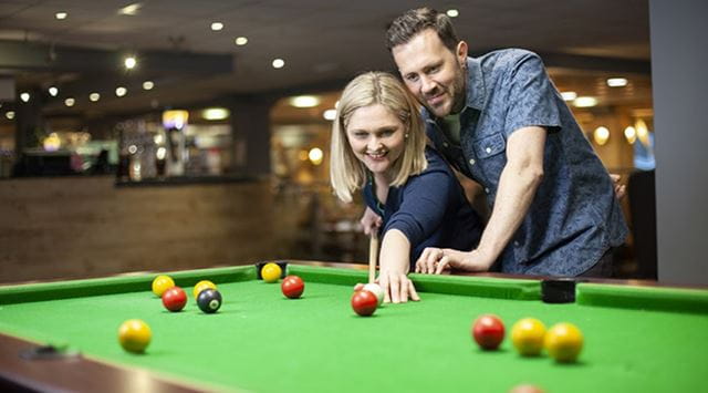 couple playing pool in a bar