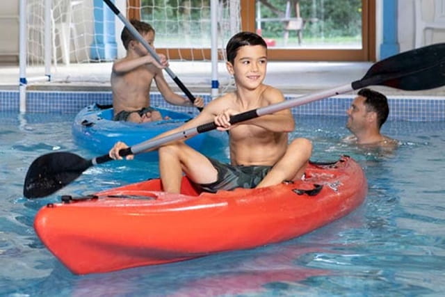 kids on kayaks in a swimming pool