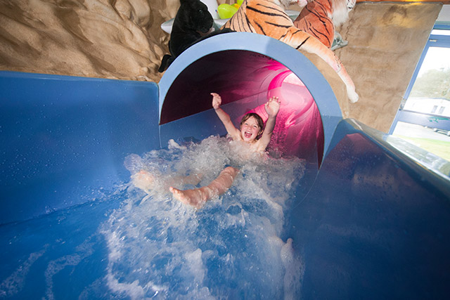 A boy sliding down the water slide at Sundrum Castle Holiday Park