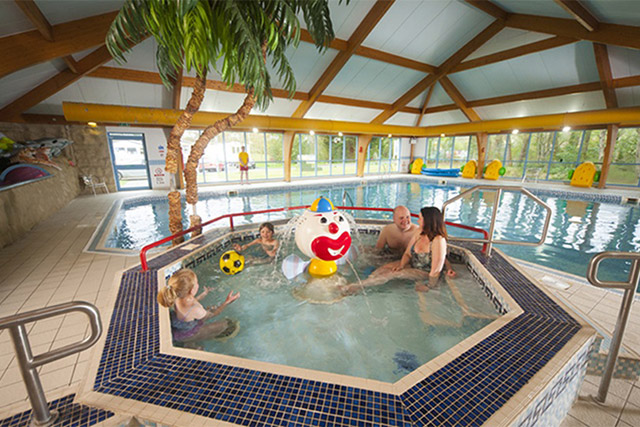 A family relaxing in the spa bath at the indoor swimming pool at Sundrum Castle Holiday Park