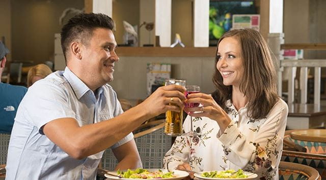 A couple enjoying drinks and a meal in The Boathouse Bar & Restaurant at Ty Mawr Holiday Park
