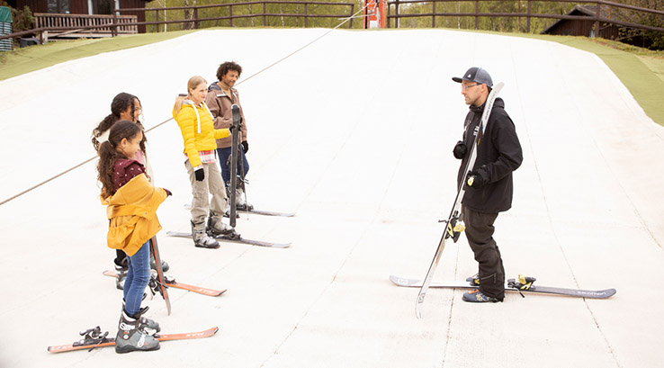 An instructor giving a ski lesson to a family at Warmwell