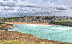 A view over Porth Beach in Cornwall, overlooked by the Mermaid Inn pub