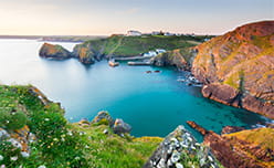 A spectacular blue sea cove surrounded by cliffs in Mullion Cornwall