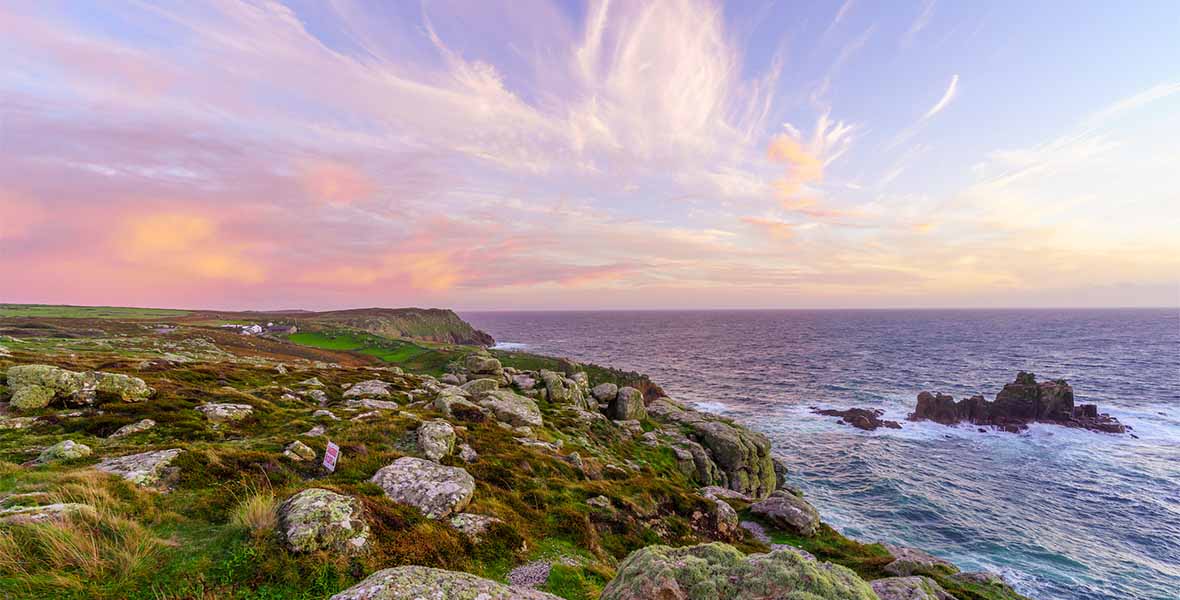 Sunset over a rocky coastal outcrop in Cornwall