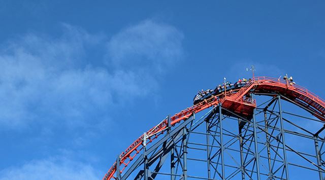 Blue skies over a roller coaster about to drop