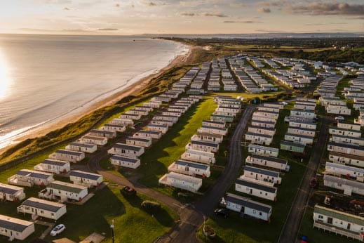 birds eye view of caravan park right next to seafront
