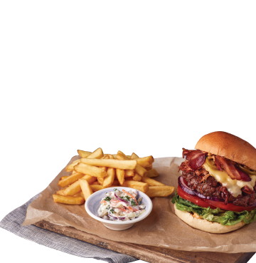 Cheeseburger and chips and coleslaw on a wooden board