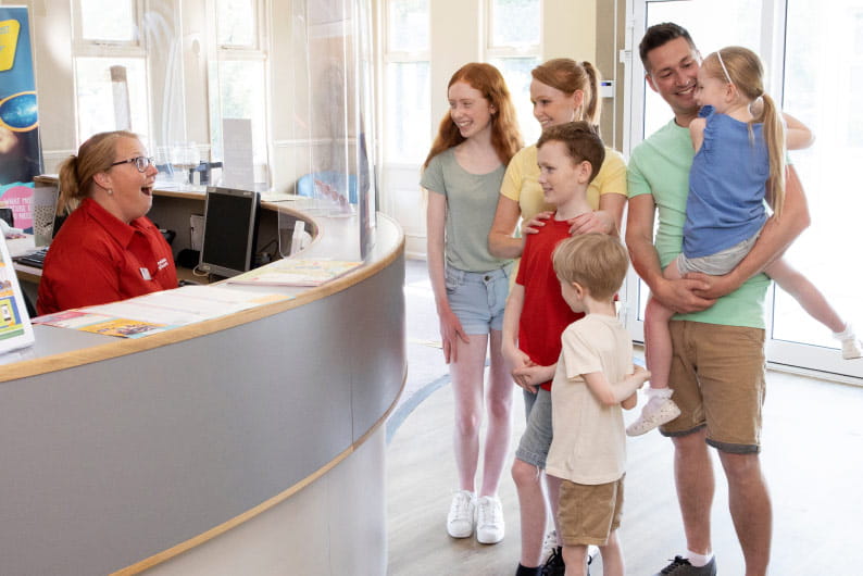 family asking questions at a help desk