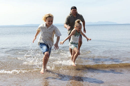 Family running in the sea smiling and having fun