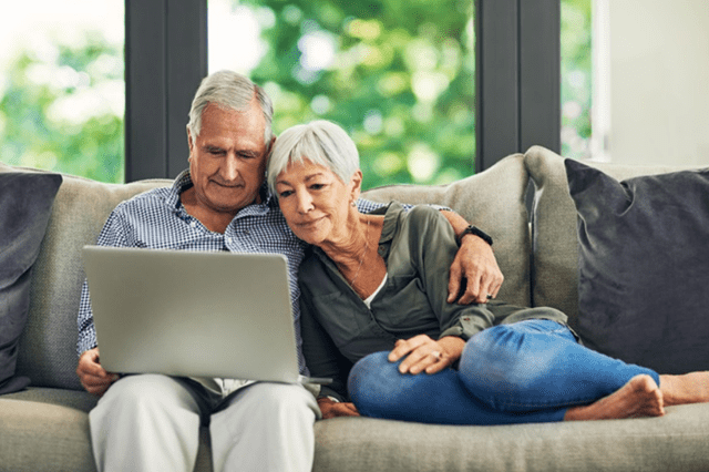 Couple searching holidays on a laptop for parkdean resorts