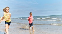 two kids running along the seashore